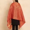 Woman wearing a luxurious red and gold embroidered shawl with black outfit.